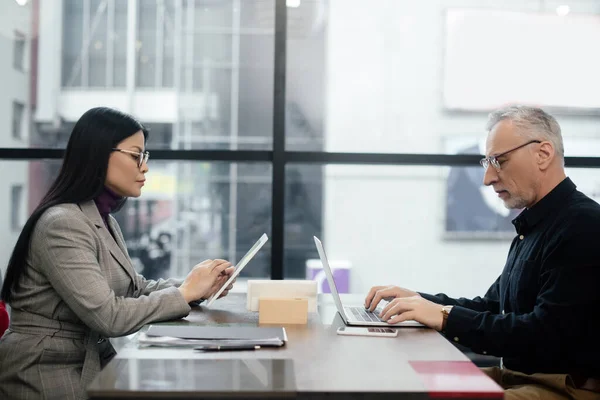 Side View Businessman Using Laptop Asian Businesswoman Using Digital Tablet — Stock Photo, Image