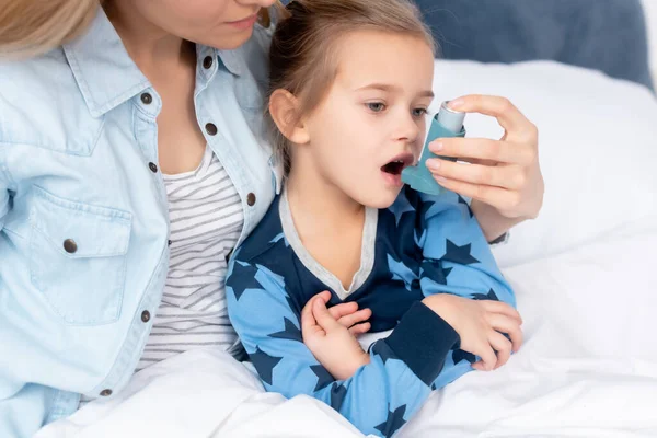 Madre Cariñosa Sosteniendo Inhalador Con Espaciador Cerca Hija Enferma — Foto de Stock