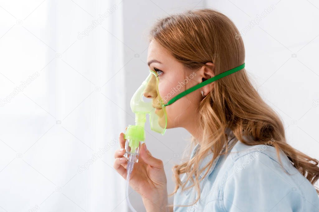 side view of asthmatic woman in respiratory mask 