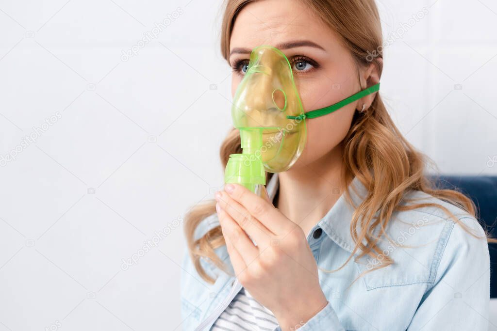 asthmatic woman using respiratory mask 