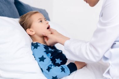 Beyaz önlüklü doktor hasta çocuğu muayene ediyor. 