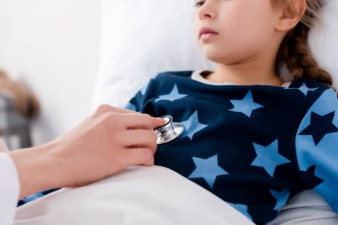 Steteskoplu bir doktorun hasta çocuğu muayene edişi. 