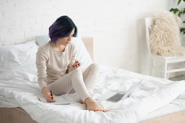 Defterine Renkli Saçlar Yazan Yatak Odasındaki Dizüstü Bilgisayarın Yanındaki Akıllı — Stok fotoğraf