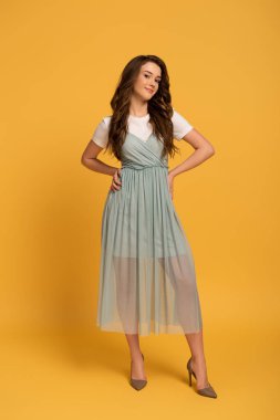 Tişörtlü ve sarı elbiseli çekici bir kız.