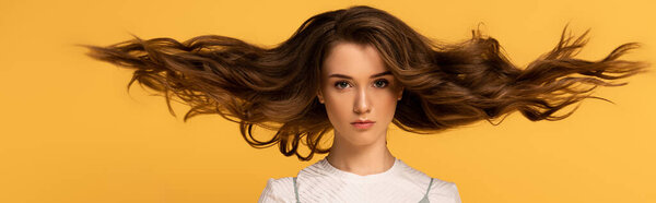 panoramic shot of beautiful confident spring woman with long hair isolated on yellow