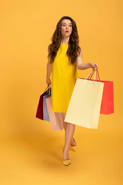 穿着雅致的春装 提着黄色购物袋的美丽而震惊的女孩 — 图库照片