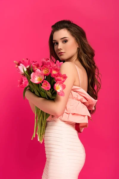 漂亮的女人 穿着雅致的衣服 手里拿着一束用粉红色隔开的春天郁金香花 — 图库照片