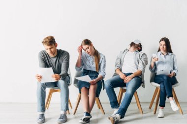 Ofiste akıllı telefon kullanan bir grup genç çalışan. 