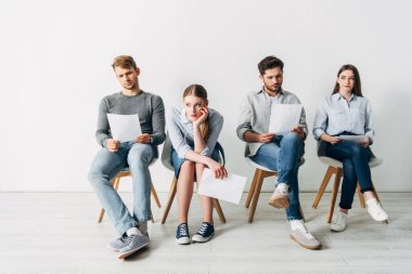 Özgeçmişi olan bir grup çalışan iş görüşmesini ofiste bekliyor. 