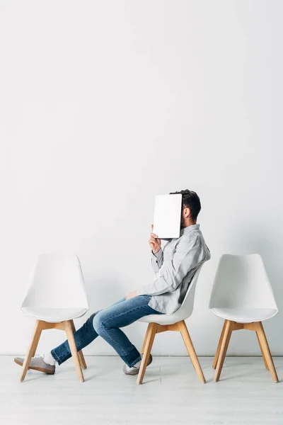 Vista Lateral Empregado Cobrindo Rosto Com Laptop Enquanto Sentado Cadeira — Fotografia de Stock