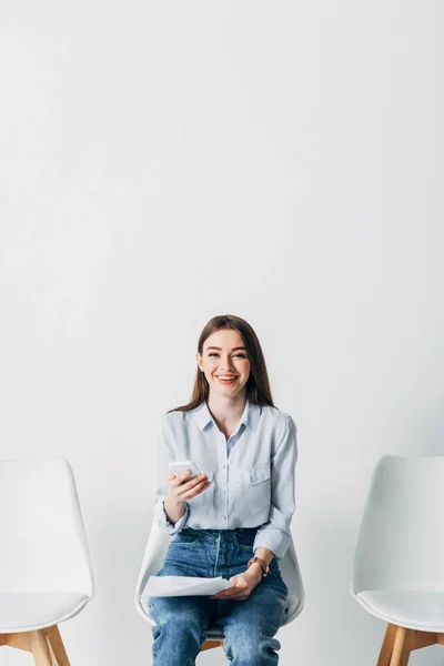 Lächelnder Mitarbeiter Blickt Die Kamera Während Smartphone Und Lebenslauf Büro — Stockfoto