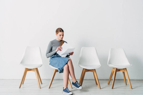 Прекрасный кандидат проведение резюме, сидя на стуле в должности
 