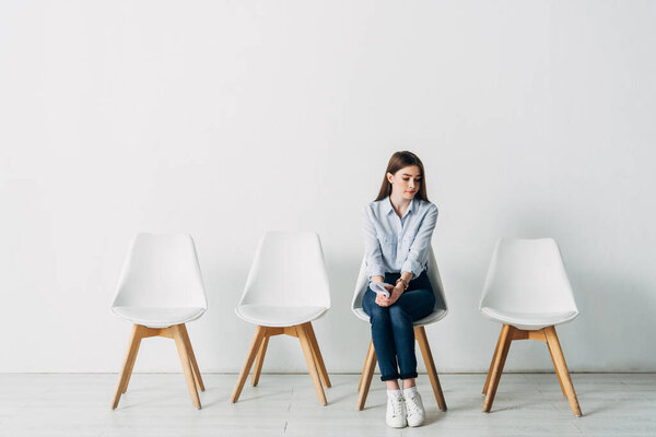 Красивый работник с резюме сидит на стуле в офисе
 