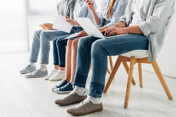 Обрезанный просмотр сотрудников, использующих цифровые устройства в офисе
 