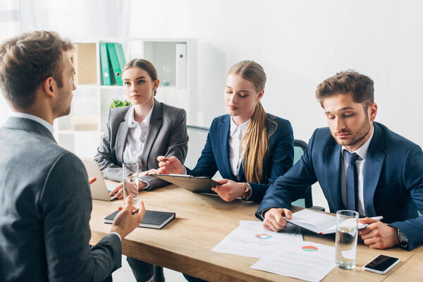 Recruiters looking at papers during job interview with employee in office 