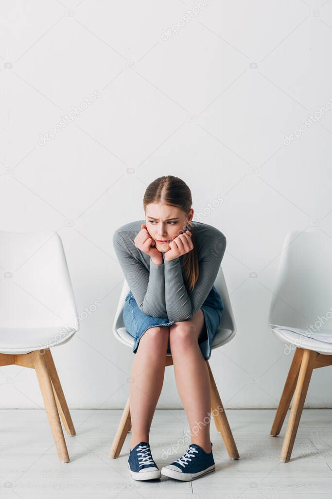 Pensive girl waiting for job interview in office 
