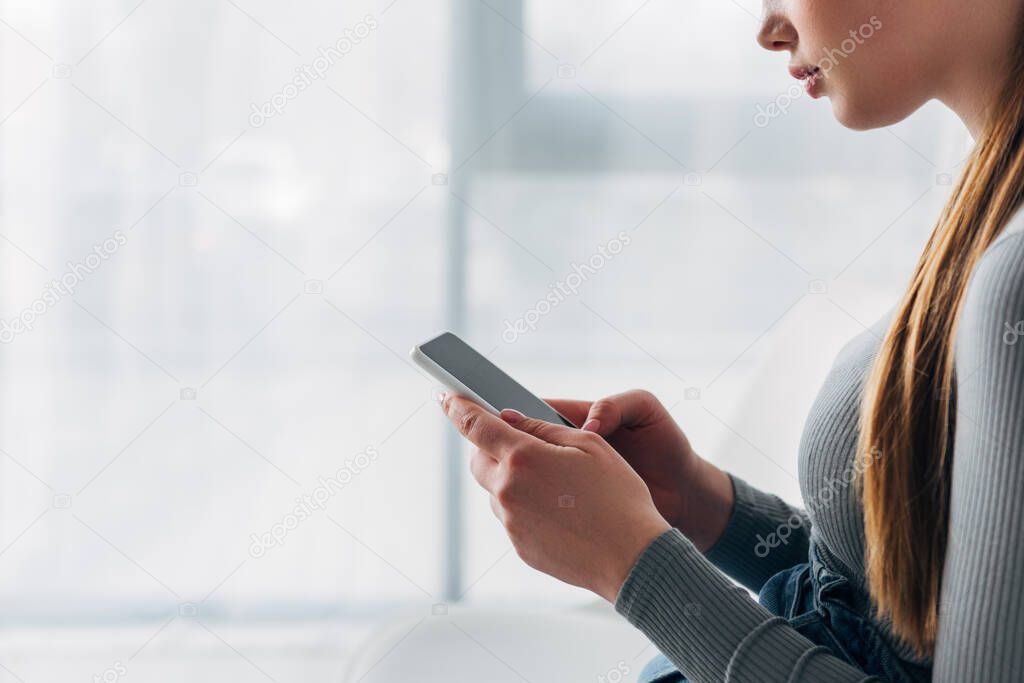 Cropped view of applicant using smartphone with blank screen in office 