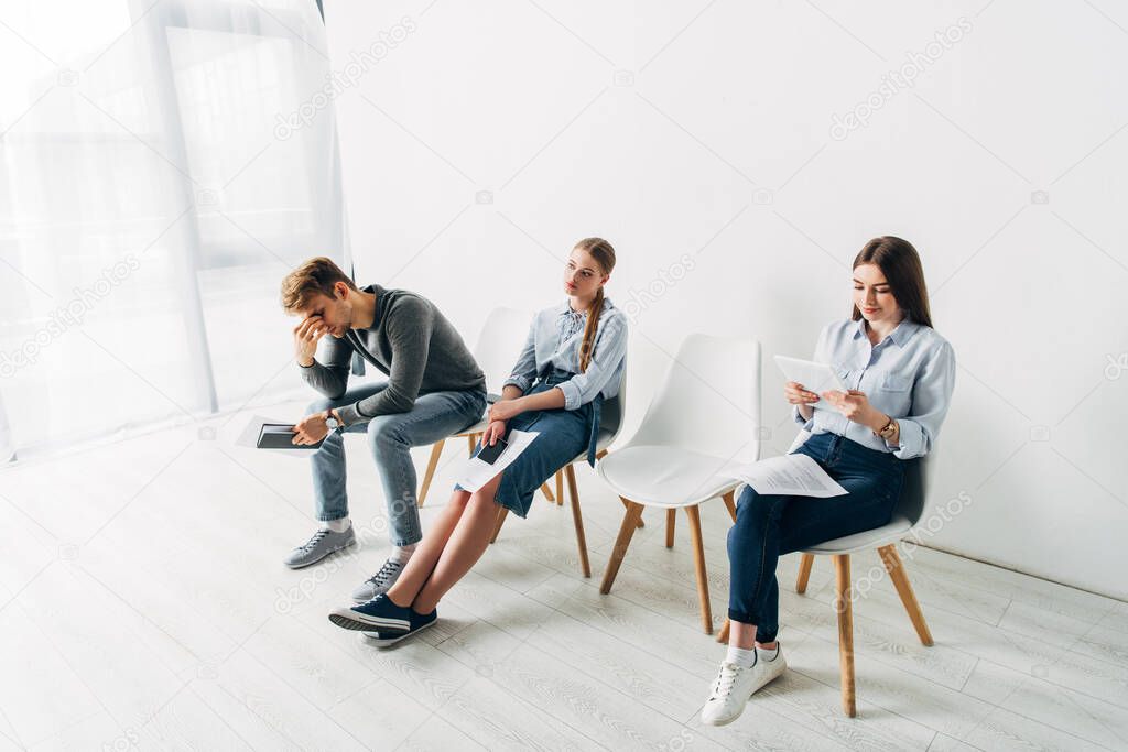 Tired man and women waiting for job interview in office 