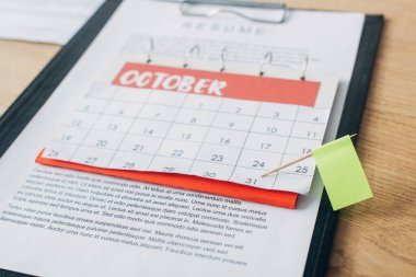 Selective focus of flag on calendar near resume on wooden table clipart