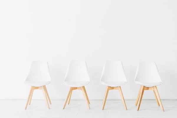 Ofisteki Beyaz Duvarın Yanındaki Sıra Sandalyeler — Stok fotoğraf