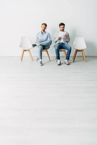 Knappe Medewerkers Met Laptop Zitten Stoelen Het Kantoor — Stockfoto