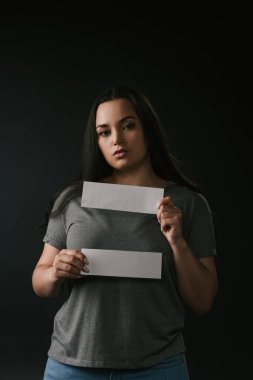 Siyah arkaplanda boş kartlar tutan büyük beden kız ön görünümü 