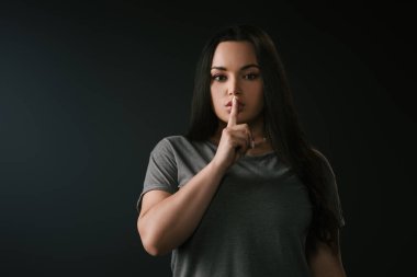 Siyah üzerine izole edilmiş sessizlik jesti ile büyük boy kız ön görünümü