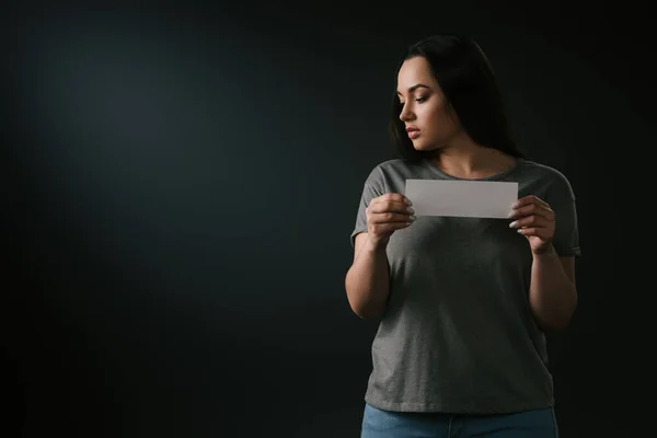 Vista Frontal Menina Triste Size Segurando Cartão Vazio Fundo Preto — Fotografia de Stock