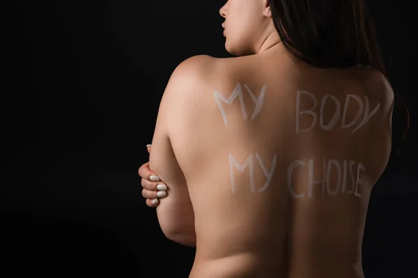 Back view of plus size model with lettering My Body My Choice on naked back isolated on black