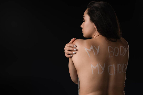 Back view of beautiful plus size model with lettering My Body My Choice on naked back isolated on black 