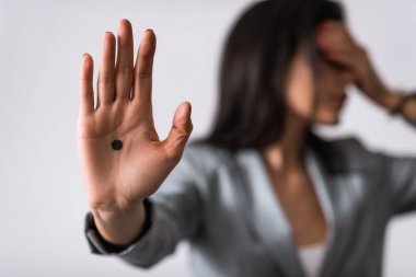 Beyaz, aile içi şiddet kavramına izole edilmiş avuç içi siyah noktalı iş kadınının seçici odağı 