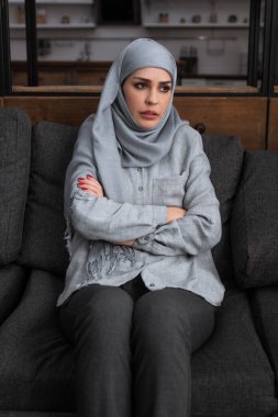 tesettürlü üzgün müslüman kadın kollarını kavuşturmuş, aile içi şiddet kavramı  