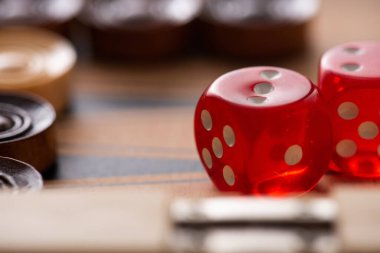KYIV, UKRAINE - JANUARY 30, 2019: selective focus of dice pair on backgammon board near checkers clipart