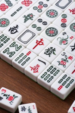 KYIV, UKRAINE - 30 HAZİRAN 2019: Ahşap masa üzerinde işaretleri ve karakterleri olan mahjong oyun fayansları alanı