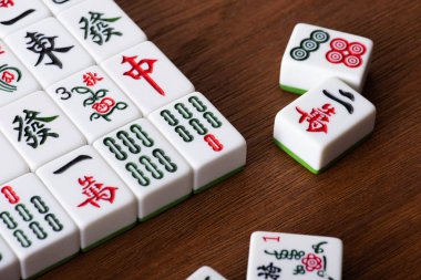 KYIV, UKRAINE - 30 HAZİRAN 2019: Ahşap masa üzerinde işaretleri ve karakterleri olan beyaz mahjong oyunu fayansları