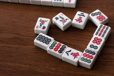 KYIV, UKRAINE - 30 HAZİRAN 2019: ahşap masa üzerindeki beyaz mahjong oyununun taşlarından yapılmış kalp sembolü