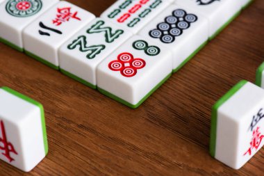 KYIV, UKRAINE - 30 HAZİRAN 2019: Tahta masa üzerindeki mahjong oyunlarının seçici odak noktaları