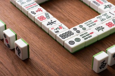 KYIV, UKRAINE - 30 HAZİRAN 2019: Tahta masa üzerindeki mahjong oyunlarının seçici odak noktaları