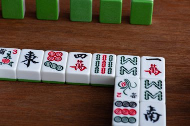 KYIV, UKRAINE - 30 HAZİRAN 2019: Ahşap masa üzerinde işaretleri ve karakterleri olan mahjong oyunu fayansları