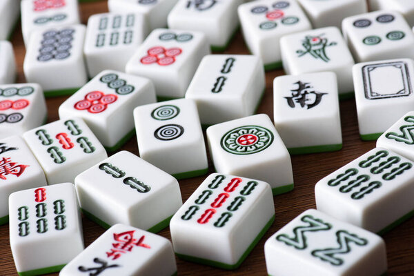 KYIV, UKRAINE - JANUARY 30, 2019: selective focus of white mahjong game tiles with signs and characters on wooden surface