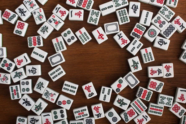 KYIV, UKRAINE - 30 HAZİRAN 2019: ahşap masa üzerindeki beyaz mahjong oyun fayansları çerçevesi, üst görünüm