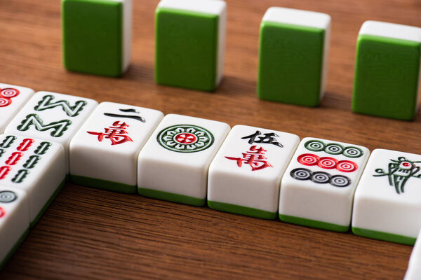 KYIV, UKRAINE - JANUARY 30, 2019: selective focus of mahjong game tiles rows on wooden table