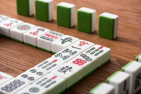 KYIV, UKRAINE - 30 HAZİRAN 2019: Tahta masa üzerindeki mahjong oyunlarının seçici odak noktaları