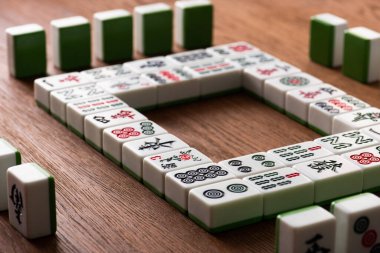 KYIV, UKRAINE - 30 HAZİRAN 2019: Ahşap masa üzerindeki beyaz mahjong fayanslarından yapılmış kare çerçevenin seçici odak noktası