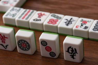 KYIV, UKRAINE - 30 HAZİRAN 2019: Tahta yüzey üzerindeki beyaz mahjong oyununun seçici odak noktası