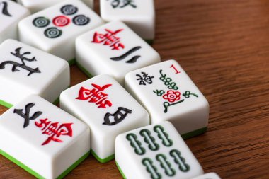 KYIV, UKRAINE - 30 HAZİRAN 2019: Ahşap yüzey üzerinde işaretleri ve karakterleri olan beyaz mahjong oyunları