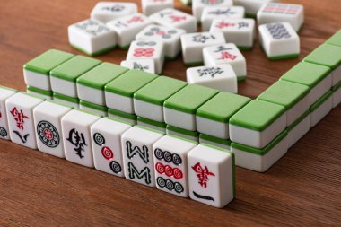 KYIV, UKRAINE - 30 HAZİRAN 2019: Tahta yüzey üzerinde işaretler ve semboller bulunan mahjong oyun fayanslarının seçici odağı