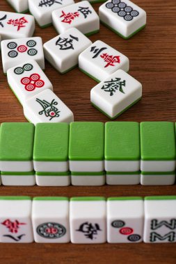 KYIV, UKRAINE - 30 HAZİRAN 2019: Tahta yüzey üzerinde işaretler ve semboller bulunan mahjong oyun fayanslarının seçici odağı