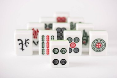 KYIV, UKRAINE - 30 HAZİRAN 2019: Beyaz arkaplanda işaretleri ve karakterleri olan mahjong oyununun seçici odak noktası