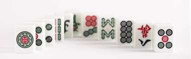 KYIV, UKRAINE - 30 HAZİRAN 2019: Beyaz arkaplanda işaretleri ve karakterleri olan mahjong oyununun seçici odak noktası, panoramik çekim